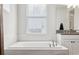 This bathroom features a soaking tub, a window, and a vanity with great counter space at 5314 Alafia Falls Dr, Lithia, FL 33547