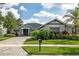Charming home showcasing a landscaped front yard, lush greenery, and a paved driveway leading to a welcoming entrance at 5314 Alafia Falls Dr, Lithia, FL 33547