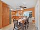Open-concept dining and kitchen area featuring a wooden table, ceiling fan, and an adjacent living area with a stone fireplace at 6067 43Rd N Ter, Kenneth City, FL 33709