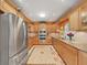 Updated kitchen features stainless steel appliances, warm wood cabinets, granite countertops, and tile flooring at 6067 43Rd N Ter, Kenneth City, FL 33709