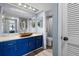 Stylish bathroom featuring blue vanity with granite countertop and a bronze vessel sink, complemented by unique decorative mirrors at 609 Lively Dr # B, Sun City Center, FL 33573