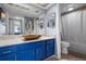 Stylish bathroom featuring blue vanity with granite countertop and a bronze vessel sink, complemented by unique decorative mirrors at 609 Lively Dr # B, Sun City Center, FL 33573