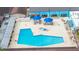Aerial view of the community pool and hot tub, showing lounge seating and tables with umbrellas at 609 Lively Dr # B, Sun City Center, FL 33573