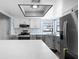 Kitchen showcasing stainless steel appliances, gray cabinets, and large island with white marble countertops at 609 Lively Dr # B, Sun City Center, FL 33573
