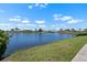 Scenic lake view surrounded by lush landscaping and beautiful homes under a clear blue sky at 609 Lively Dr # B, Sun City Center, FL 33573