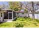 Lush backyard featuring a screened-in porch, a well-maintained lawn, and mature trees providing plenty of shade at 6114 7Th S Ave, Gulfport, FL 33707