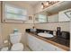 Bright bathroom featuring a granite countertop, modern vanity, and window that provides natural light at 6114 7Th S Ave, Gulfport, FL 33707