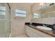 Bathroom featuring a shower, vanity, granite countertops, and a window that provides natural light at 6114 7Th S Ave, Gulfport, FL 33707
