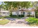 Charming single-story home featuring a well-manicured lawn, brick driveway, and mature shade tree at 6114 7Th S Ave, Gulfport, FL 33707