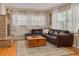 Cozy living room featuring hardwood floors, a brick fireplace, and a comfortable sectional sofa at 6114 7Th S Ave, Gulfport, FL 33707