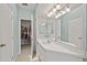 Bright bathroom features a long vanity, mirror, and an open door to the walk-in closet at 616 Garland Cir, Indian Rocks Beach, FL 33785