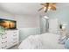 Relaxing main bedroom features a ceiling fan, tv, and light blue accent wall at 616 Garland Cir, Indian Rocks Beach, FL 33785