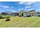 Backyard view with a screened pool, lanai, lush lawn, and garage, ideal for outdoor living at 6425 Clair Shore Dr, Apollo Beach, FL 33572