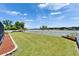 Fenced backyard features a large grassy area and lake views at 6425 Clair Shore Dr, Apollo Beach, FL 33572