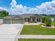 Charming home with a three-car garage, a well-manicured lawn, and beautiful landscaping at 6425 Clair Shore Dr, Apollo Beach, FL 33572