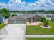 Well-maintained home showcasing a three-car garage, beautiful landscaping, and serene lake view at 6425 Clair Shore Dr, Apollo Beach, FL 33572