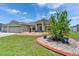 Charming home exterior featuring manicured lawn, colorful flower beds, and inviting entryway at 6425 Clair Shore Dr, Apollo Beach, FL 33572