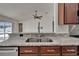 Granite countertops, stainless steel sink, and wood cabinetry in the kitchen overlooking the pool at 6425 Clair Shore Dr, Apollo Beach, FL 33572