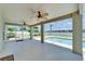 Enclosed lanai with fans looks out onto a backyard pool and lake at 6425 Clair Shore Dr, Apollo Beach, FL 33572
