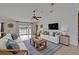 Comfortable living room featuring vaulted ceiling, large screen television, and view of the pool at 6425 Clair Shore Dr, Apollo Beach, FL 33572