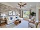 Cozy living room with wood-look accent wall, comfortable seating, and ample natural light at 6425 Clair Shore Dr, Apollo Beach, FL 33572