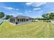 Backyard features a screened-in pool, green lawn, and manicured landscaping at 6425 Clair Shore Dr, Apollo Beach, FL 33572