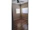 Bedroom featuring a ceiling fan, two windows for natural light, and hardwood floors at 6434 Old Main St, New Port Richey, FL 34653