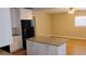Bright kitchen with island open to the living room, showcasing granite countertops and black appliances at 6434 Old Main St, New Port Richey, FL 34653