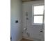 A basic laundry area with white walls, plumbing, and a small window for natural light at 6434 Old Main St, New Port Richey, FL 34653