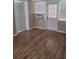 Bright living room featuring wood-look floors, neutral walls, and natural light from the large windows at 6434 Old Main St, New Port Richey, FL 34653