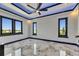 Bright bedroom featuring multiple windows, modern lighting, and ceiling fan over luxurious marble flooring at 6522 Simone Shores Cir, Apollo Beach, FL 33572