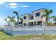 View of the back of the house and a white picket fence from across the yard at 6522 Simone Shores Cir, Apollo Beach, FL 33572