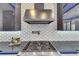 Modern kitchen with stainless steel range hood and chevron tile backsplash at 6522 Simone Shores Cir, Apollo Beach, FL 33572