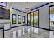 Contemporary living room with marble flooring, modern light fixtures, and sliding doors to the outside at 6522 Simone Shores Cir, Apollo Beach, FL 33572