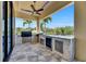 A covered outdoor kitchen includes a grill, mini-fridge, sink, and countertop at 6522 Simone Shores Cir, Apollo Beach, FL 33572