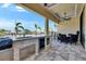 Outdoor patio with built-in kitchen, seating area, and view of the waterfront at 6522 Simone Shores Cir, Apollo Beach, FL 33572