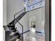 Elegant staircase with black and glass railing, marble floors, and contemporary lighting fixtures at 6522 Simone Shores Cir, Apollo Beach, FL 33572