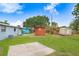 Wide shot of a green backyard with multiple storage sheds surrounded by chain link fencing at 660 11Th N Ave, Safety Harbor, FL 34695