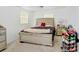 Bright bedroom boasts a large bed with tufted headboard, neutral walls and carpet, and a mirrored nightstand at 660 11Th N Ave, Safety Harbor, FL 34695