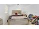 Well-lit bedroom featuring a large bed with a tufted headboard, neutral carpet, and a shoe rack on the side at 660 11Th N Ave, Safety Harbor, FL 34695