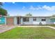 A single-story blue home with an attached garage, complemented by a green lawn and a walkway to the front door at 660 11Th N Ave, Safety Harbor, FL 34695