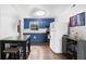 Bright kitchen features blue cabinets, a white refrigerator, a dining table and hardwood floors at 660 11Th N Ave, Safety Harbor, FL 34695