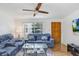 Inviting living room features a comfortable blue sofa, a glass coffee table, wood floors and lots of natural light at 660 11Th N Ave, Safety Harbor, FL 34695
