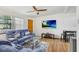 Inviting living room with a comfortable blue sectional sofa, a glass coffee table, and a mounted flat-screen television at 660 11Th N Ave, Safety Harbor, FL 34695