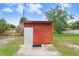 Exterior view of the small red storage shed with a concrete base in the backyard at 660 11Th N Ave, Safety Harbor, FL 34695