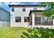 Backyard with grass and a screened-in porch in a well maintained, neutral outdoor space at 7203 1/2 S West Shore Blvd, Tampa, FL 33616