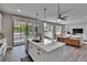 Open kitchen with quartz countertops, stainless steel appliances, island, and sliding glass doors leading to patio at 7203 1/2 S West Shore Blvd, Tampa, FL 33616