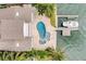 Aerial view of a home with a uniquely shaped pool, spa, private dock, and lush, mature landscaping at 803 Harbor Dr, Belleair Beach, FL 33786