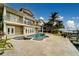Backyard featuring a modern pool, adjacent spa, waterfront views, and a private boat dock at 803 Harbor Dr, Belleair Beach, FL 33786