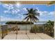 Enjoy breathtaking waterfront views from the balcony, with a palm tree, dock, and boat lift visible at 803 Harbor Dr, Belleair Beach, FL 33786